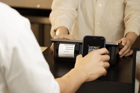 A person scans a QR code on a labeled food container using a mobile device.