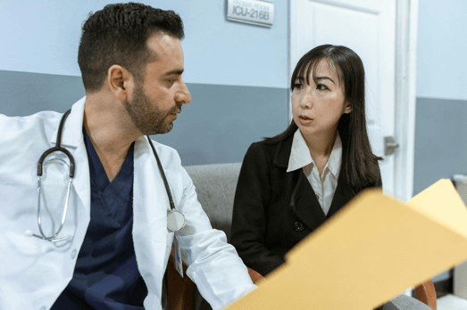 A male medical professional and a lady are discussing an incident with a folder held open.