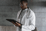A doctor in a white coat, holding a tablet, stands in a professional, modern clinical setting