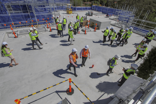 A group of construction workers standing on top of a building